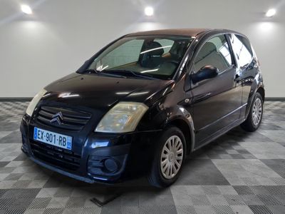 la photo d'une petite voiture noire sur un sol en damier
