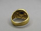 a close up of a gold ring with a blue stone in it