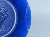 a blue plate with a picture of a woman on it