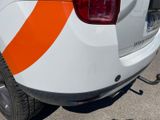 a white van with orange stripes parked in a parking lot