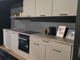 a kitchen with a sink, stove, oven, and picture frame on the wall