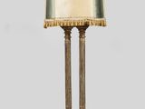 une grande lampe de table en laiton surmontée d'un abat-jour doré