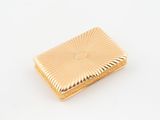 an image of a gold cigarette case sitting on a white surface