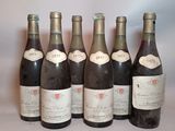 six bottles of wine are lined up on a table