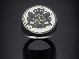 une bague en argent sur laquelle sont gravés un lion et une couronne