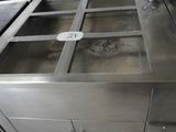 un évier en acier inoxydable dans une cuisine équipée d'un plan de travail en métal