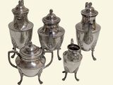 four silver vases with handles on each of them