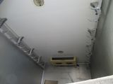 a bathroom with a toilet and a ladder in it