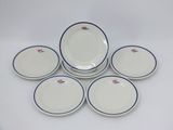 six assiettes blanches et bleues, bordées de bleu, sont disposées sur une surface blanche