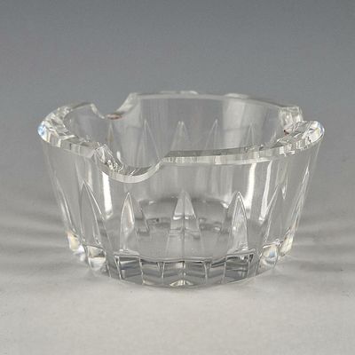 un saladier en verre transparent posé sur une table, sur fond gris