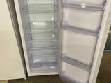 a white refrigerator with its door open in a room
