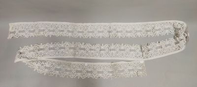 deux jarretières en dentelle blanche posées sur une table avec un fond blanc