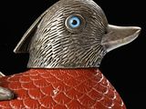 a red and silver duck with blue eyes sitting on a red object