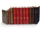 plusieurs vieux livres sont alignés sur une surface blanche