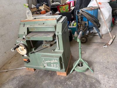 a machine that is sitting in a garage next to a pile of junk