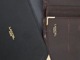 a black wallet and a brown wallet on a table