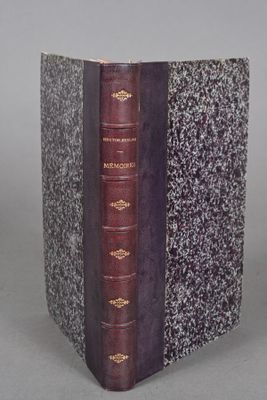 an old book sitting on top of a table next to a gray wall
