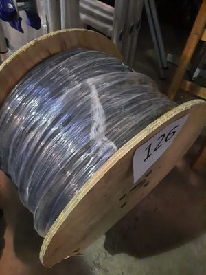 un gros rouleau de fil métallique posé par terre à côté d'une chaise