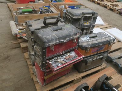 de nombreuses caisses d'outils posées sur des palettes dans un entrepôt