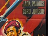 movie poster of a man holding a gun in front of a red background