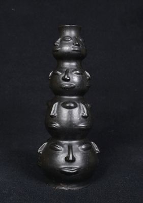 a close up of a sculpture of three faces on top of each other