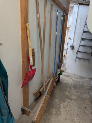 un tas de balais et une brosse par terre