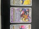 three pokemon cards are sitting on a black surface