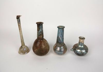 Plusieurs vases de différentes couleurs sont alignés sur une surface blanche