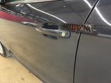 a close up of a car door handle with a sticker on it