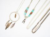 Plusieurs colliers et bracelets différents sont présentés sur un fond blanc