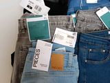 several pairs of jeans are stacked on top of each other