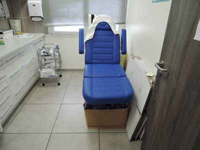 une photo d'une salle de consultation avec une chaise bleue