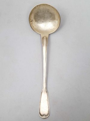 cuillère en argent posée sur une surface blanche