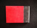 a close up of a small red and black object on a black surface