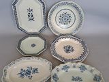 Plusieurs types d'assiettes bleues et blanches sont disposées sur une table