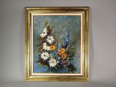 un tableau représentant des fleurs, dans un cadre doré, accroché au mur