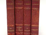 trois livres rouges sont empilés sur une surface blanche