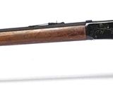 un fusil sur fond blanc, avec un support en verre pour le maintenir en place
