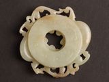 an image of a white jade circular pendant on a black surface