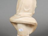 marble bust of a woman with a hat on top of it