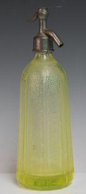 une bouteille en verre jaune munie d'un robinet en métal sur le dessus