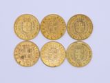 four gold coins with a coat of arms on them on a white surface