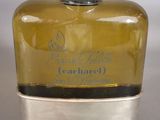 a bottle of perfume sitting on top of a silver container