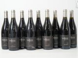 six bouteilles de vin sont alignées sur une surface blanche