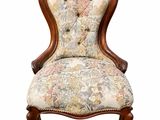 a close up of a chair with a floral upholstered back