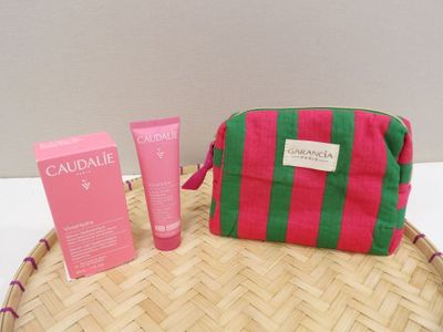 un sac rose et vert posé sur un plateau en osier