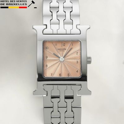 a silver watch with a pink face on a bracelet