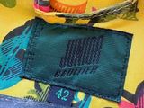 un gros plan sur un sac jaune muni d'une poignée bleue