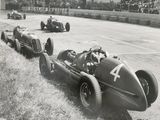 une photo en noir et blanc montrant un groupe de voitures sur un circuit automobile