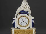 une horloge blanche et bleue surmontée d'une statue